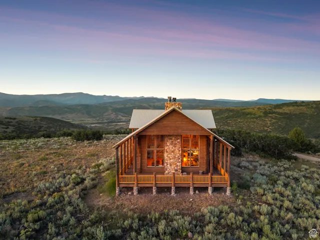 View of front of property with a chimney, a mountain view, and a metal roof
