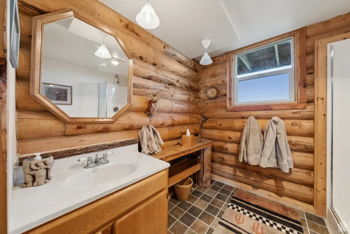 Bathroom featuring vanity and rustic walls