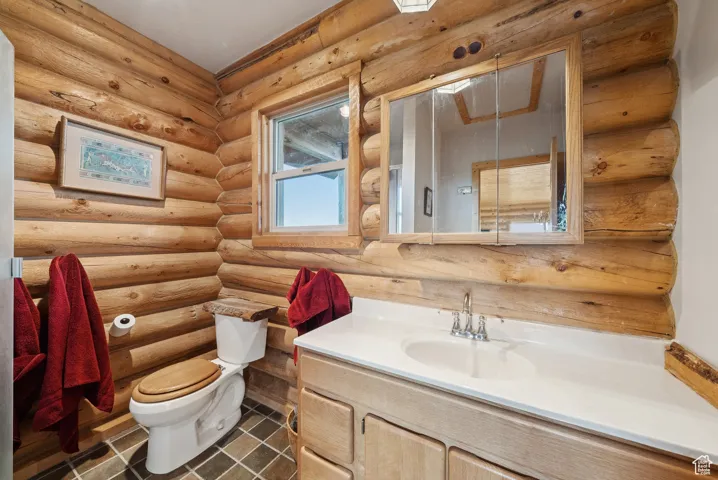 Bathroom featuring vanity and log walls