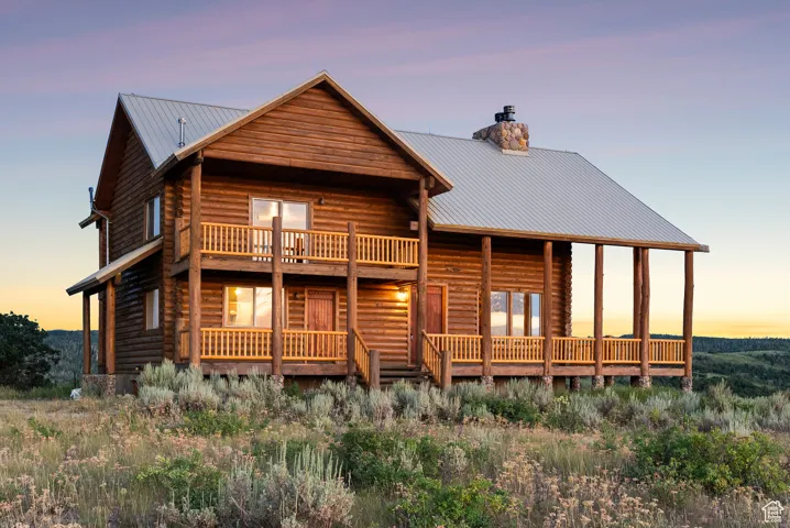 View of front of home featuring a chimney, a metal roof, and log exterior
