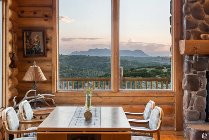 Dining room with rustic walls, a mountain view, wood finished floors, and healthy amount of natural light
