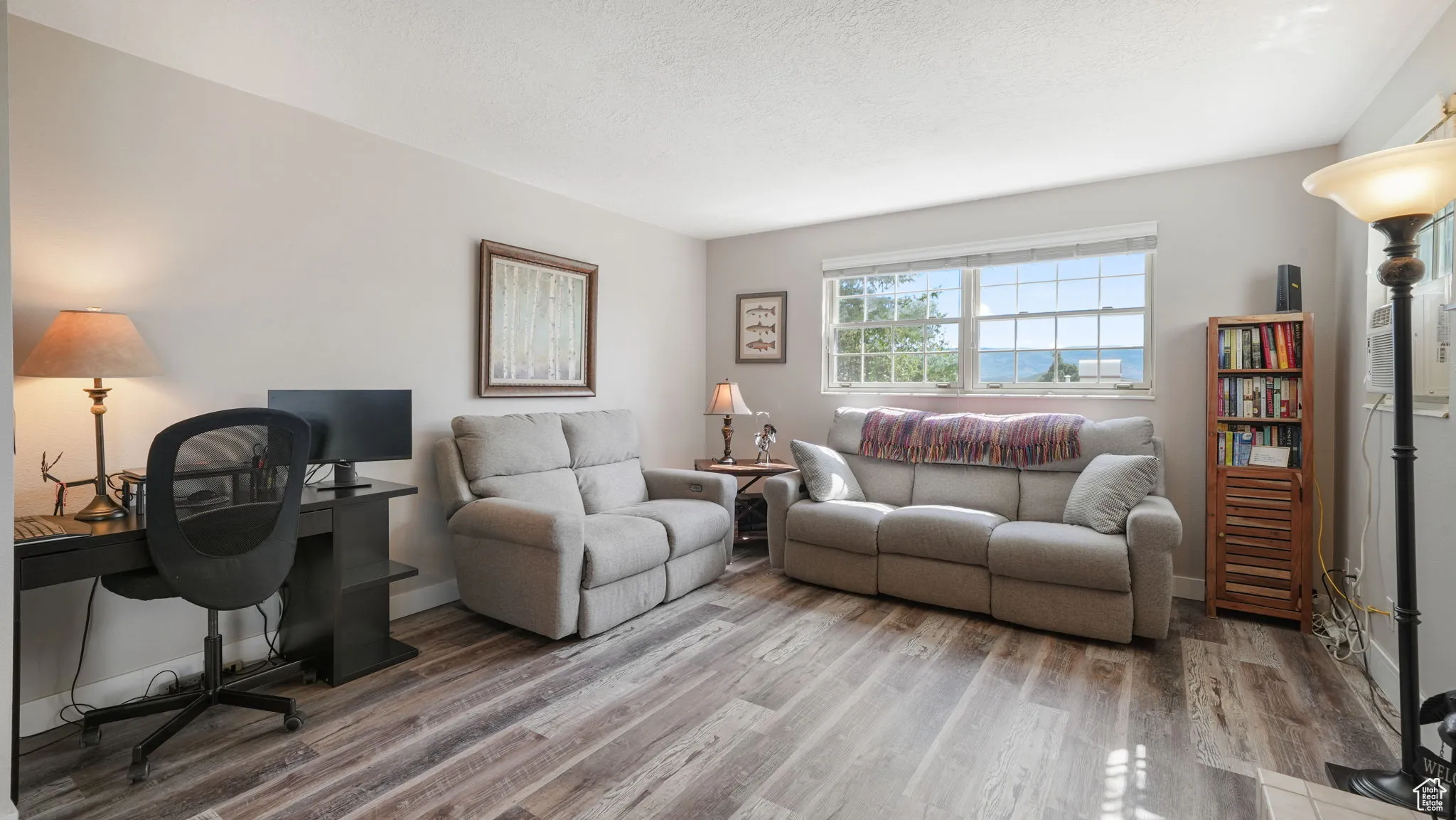 Living room with wood finished floors and an office area