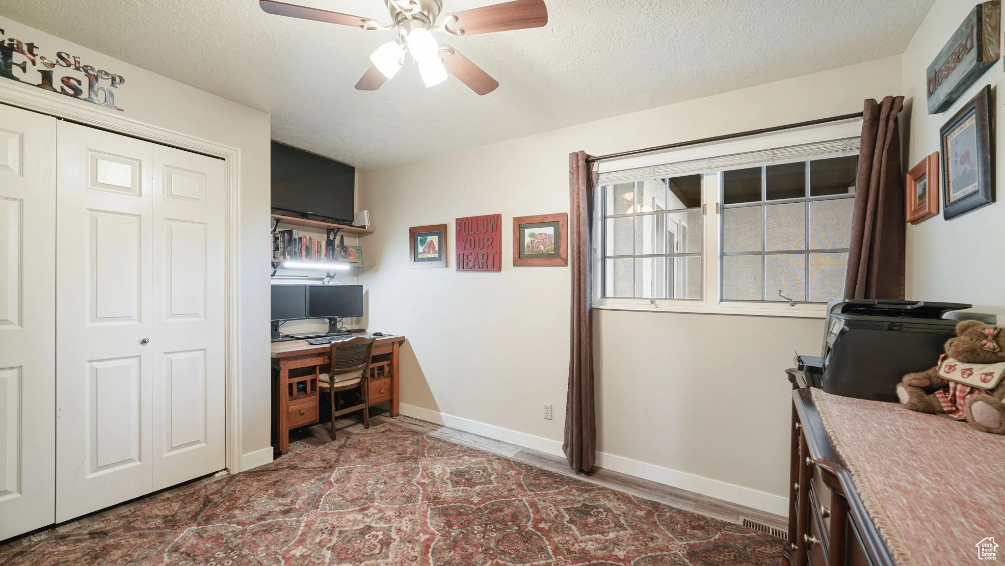 Office space with ceiling fan, a textured ceiling, and wood finished floors