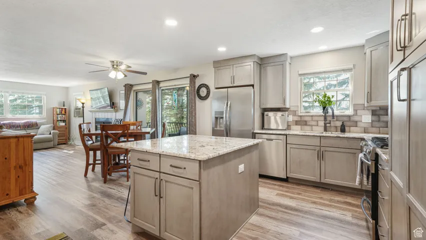Kitchen featuring appliances with stainless steel finishes, healthy amount of natural light, a ceiling fan, a kitchen island, and recessed lighting