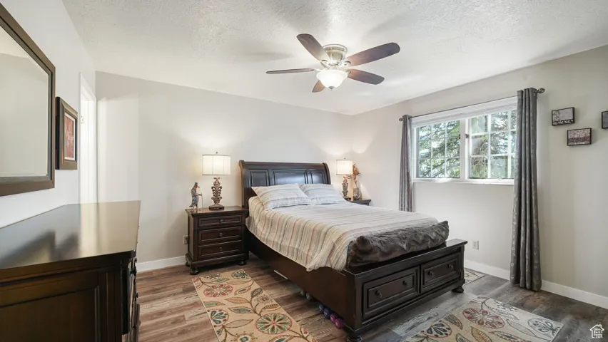 Bedroom featuring wood finished floors, a textured ceiling, and a ceiling fan