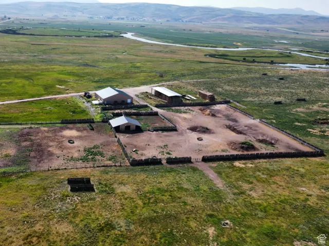 Aerial view of property and surrounding area featuring rural landscape and a mountain backdrop