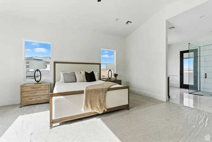 Primary bedroom with multiple windows and high vaulted ceiling