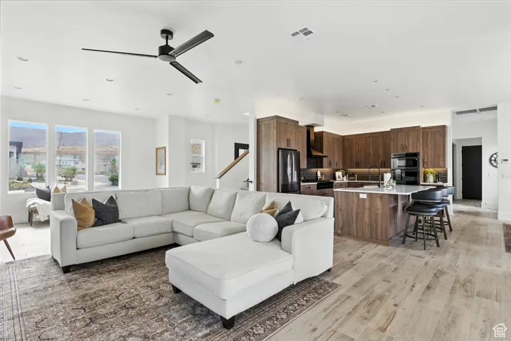 Living area with light wood-type flooring and ceiling fan