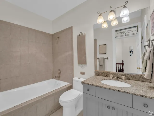 Bathroom with vanity, tiled shower / bath combo, and tile patterned flooring