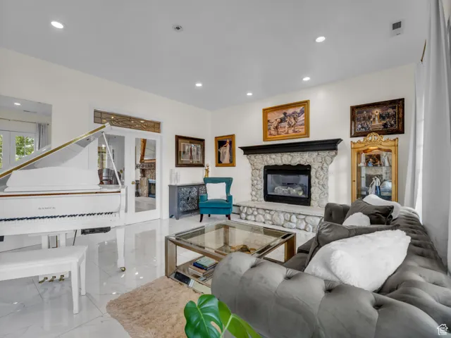 Marble flooring, living area featuring a fireplace, recessed lighting, and french doors