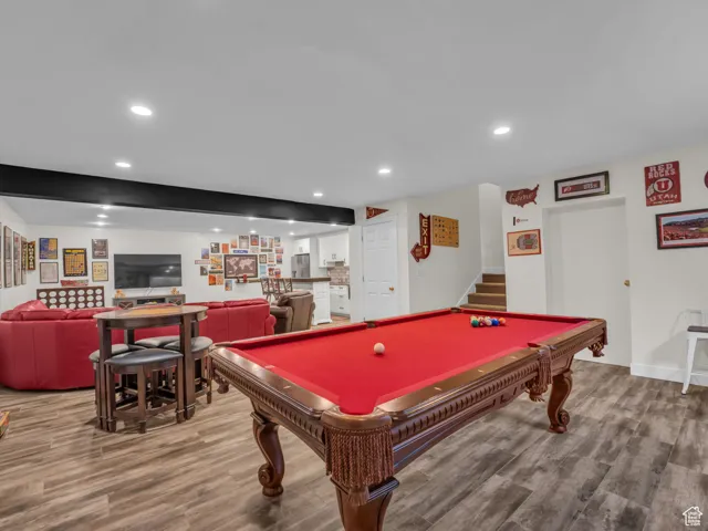 Playroom with wood finished floors, pool table, recessed lighting, and bar