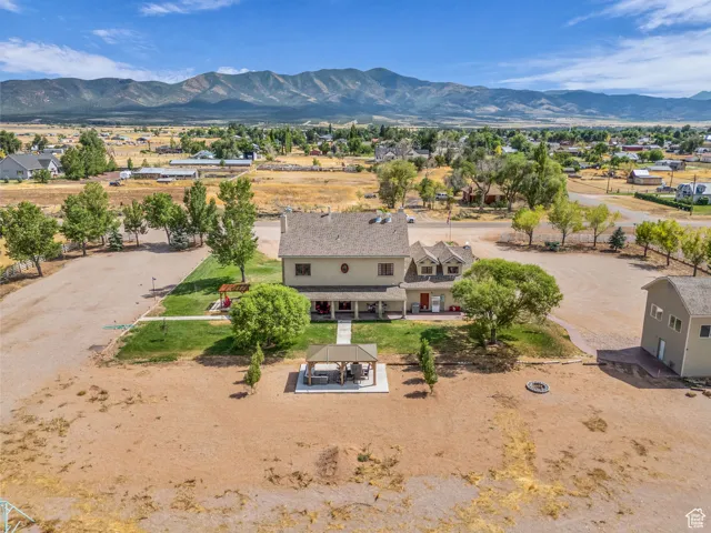 Aerial view of property and surrounding area featuring a mountainous background