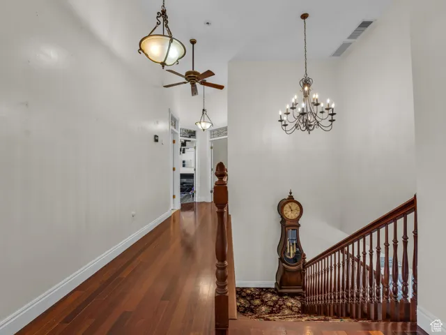 Corridor featuring hardwood  floors and a chandelier