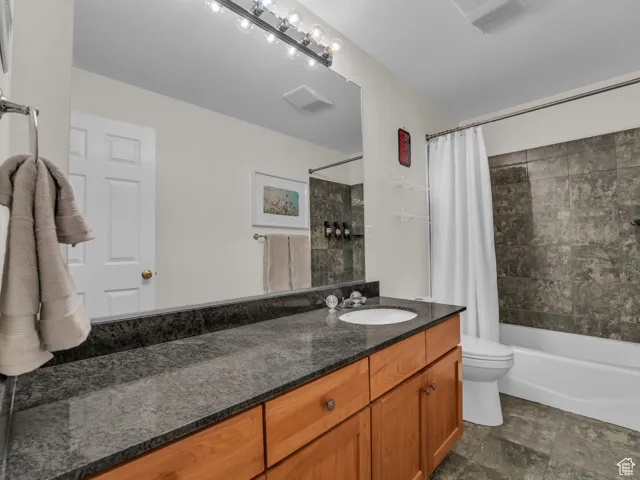 Bathroom featuring vanity and shower / tub combo with curtain