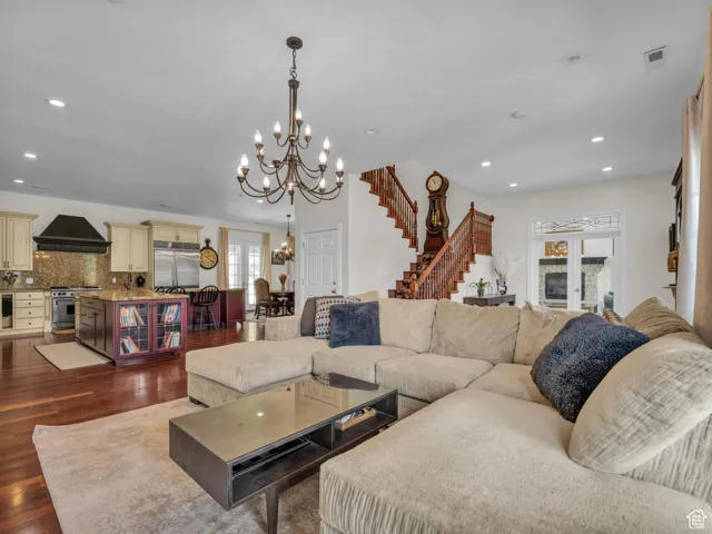 Living area with a chandelier, stairs, hard wood flooring, and recessed lighting