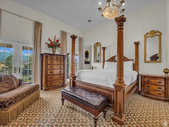 Bedroom with carpet, access to exterior, french doors, and a chandelier