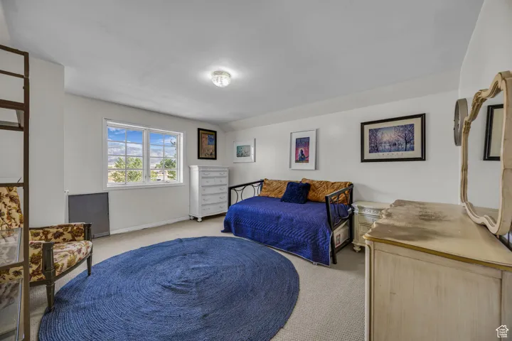 Bedroom featuring light carpet and a mountain view. Located above the second level.