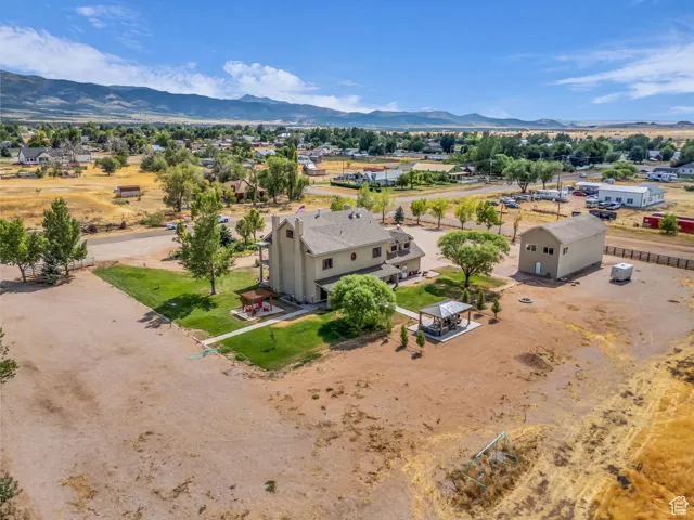 Aerial view of property and surrounding area featuring a mountainous background