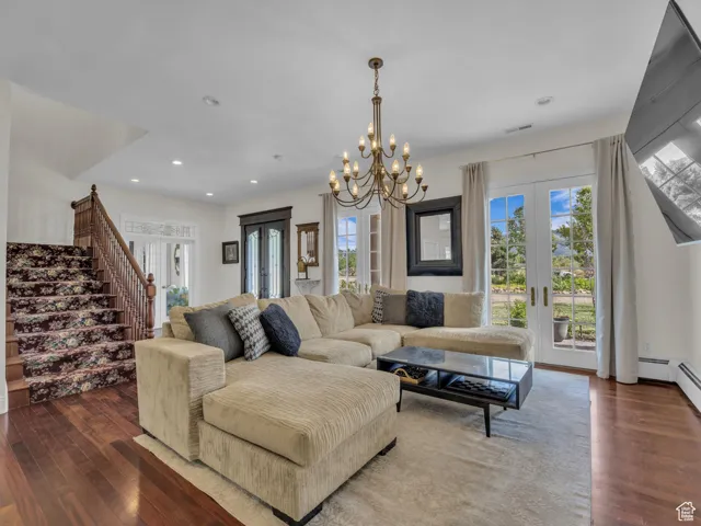 Living area featuring french doors, hard wood floors, healthy amount of natural light, and recessed lighting