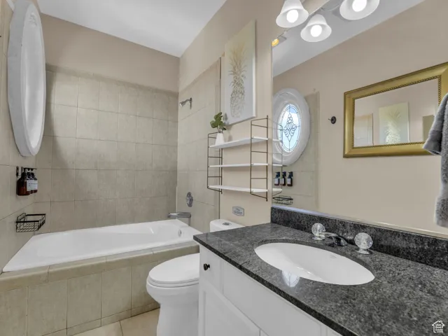 Bathroom featuring tile patterned flooring, vanity, and tiled shower / bath