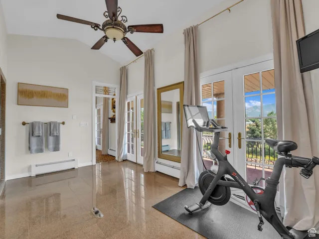 Exercise room featuring french doors, ceiling fan, baseboard heating, marble floors, and high vaulted ceiling