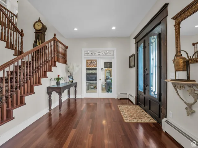 Entryway with french doors, a baseboard radiator, stairs, hardwood floors, and recessed lighting