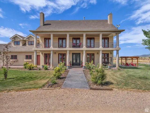 Features  french doors, a chimney, a front lawn, and stucco siding