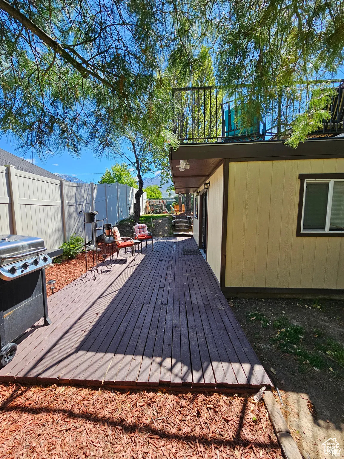 Deck with a fenced backyard and a grill