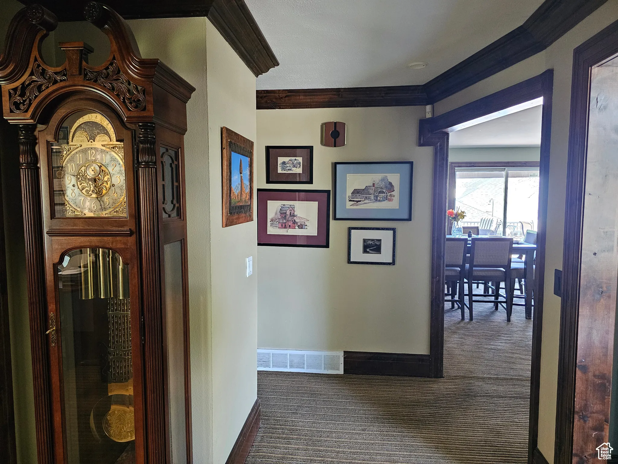 Hallway with dark carpet and crown molding