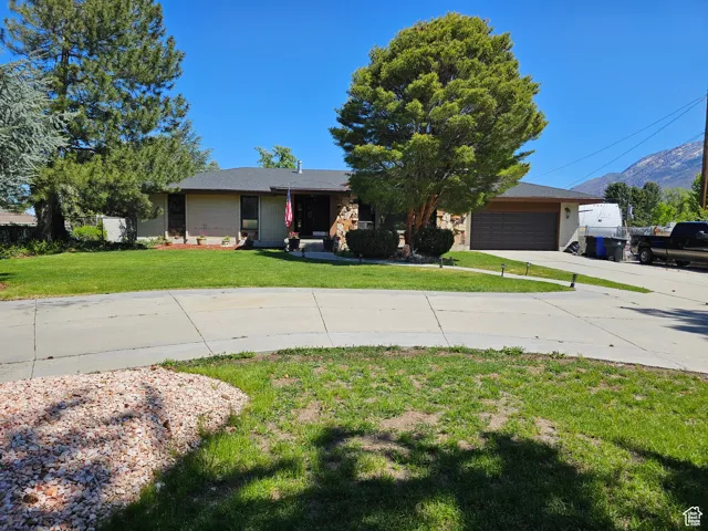 View of front facade with concrete driveway, a garage, and a mountain view