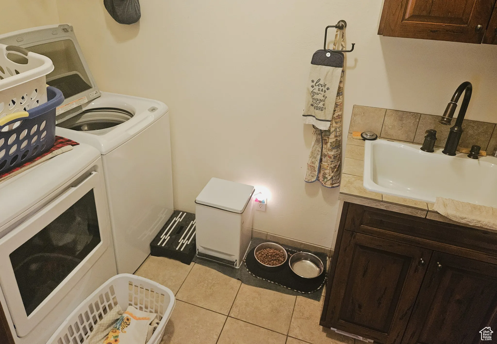 A generous laundry area with a sink provides both workspace and practicality, making laundry day a breeze.