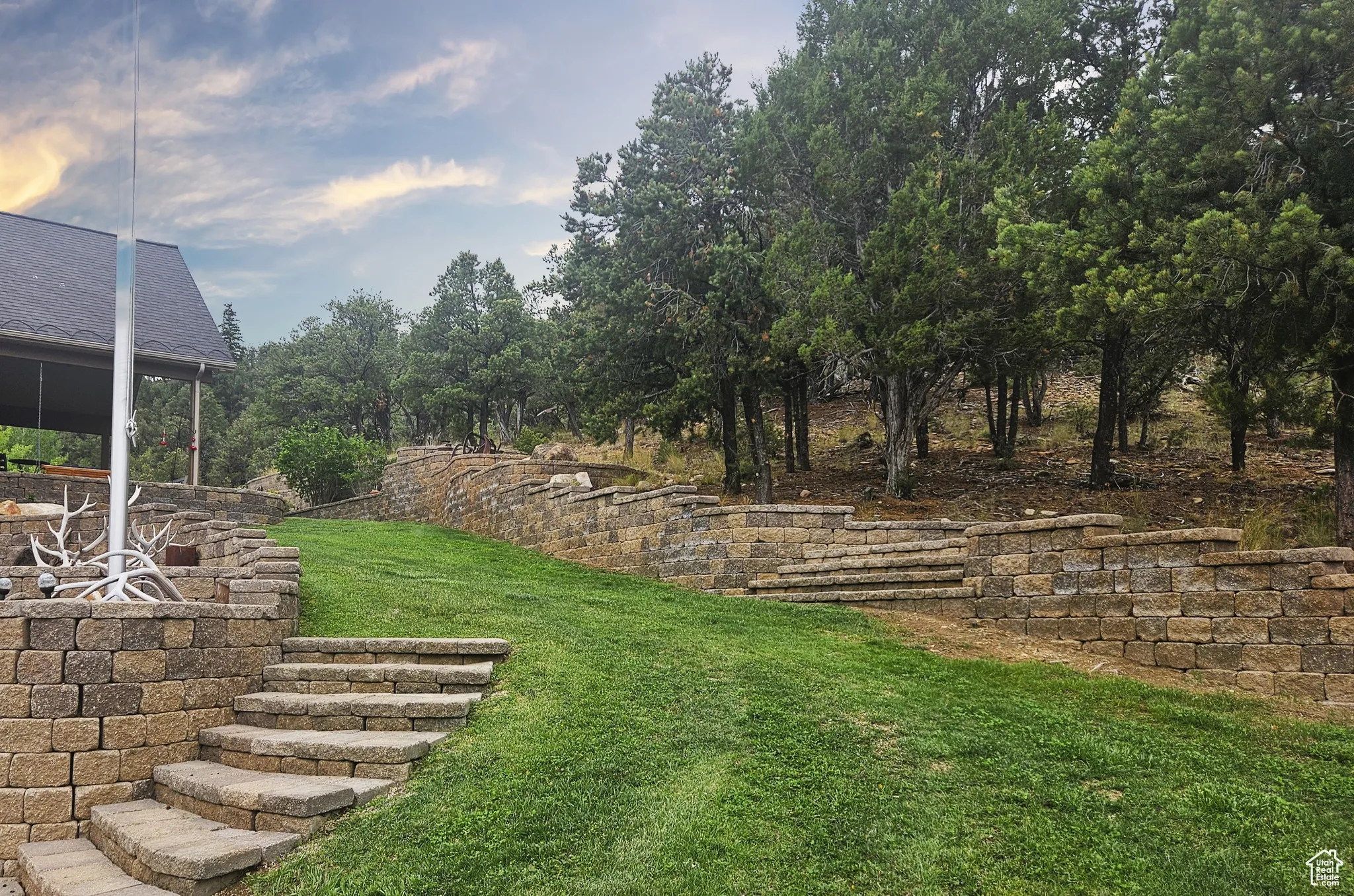 Stone steps lead gracefully through the terraced yard, guiding you to a beautifully covered patio—perfect for evening gatherings or morning solitude in the mountain air.