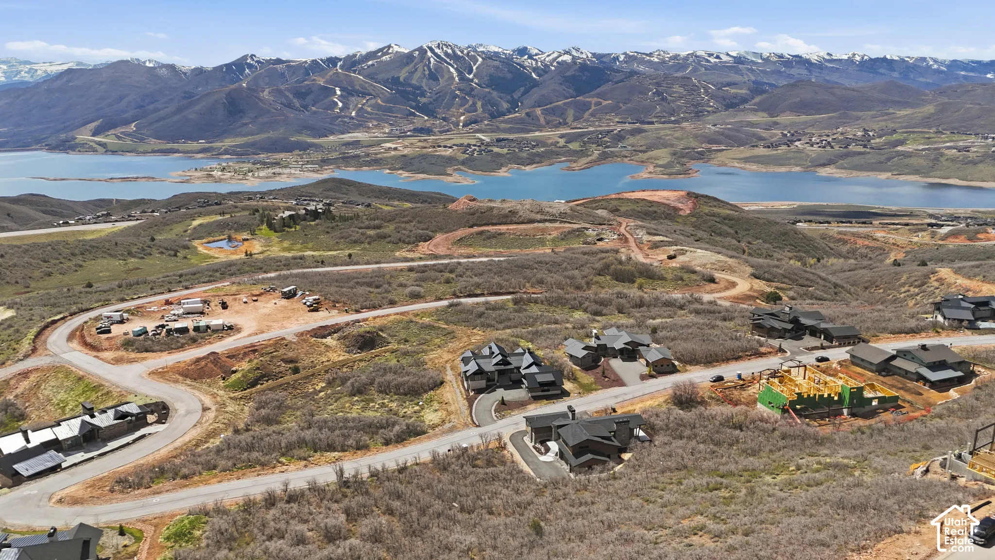 Aerial view of property and surrounding area featuring a water and mountain view and nearby suburban area