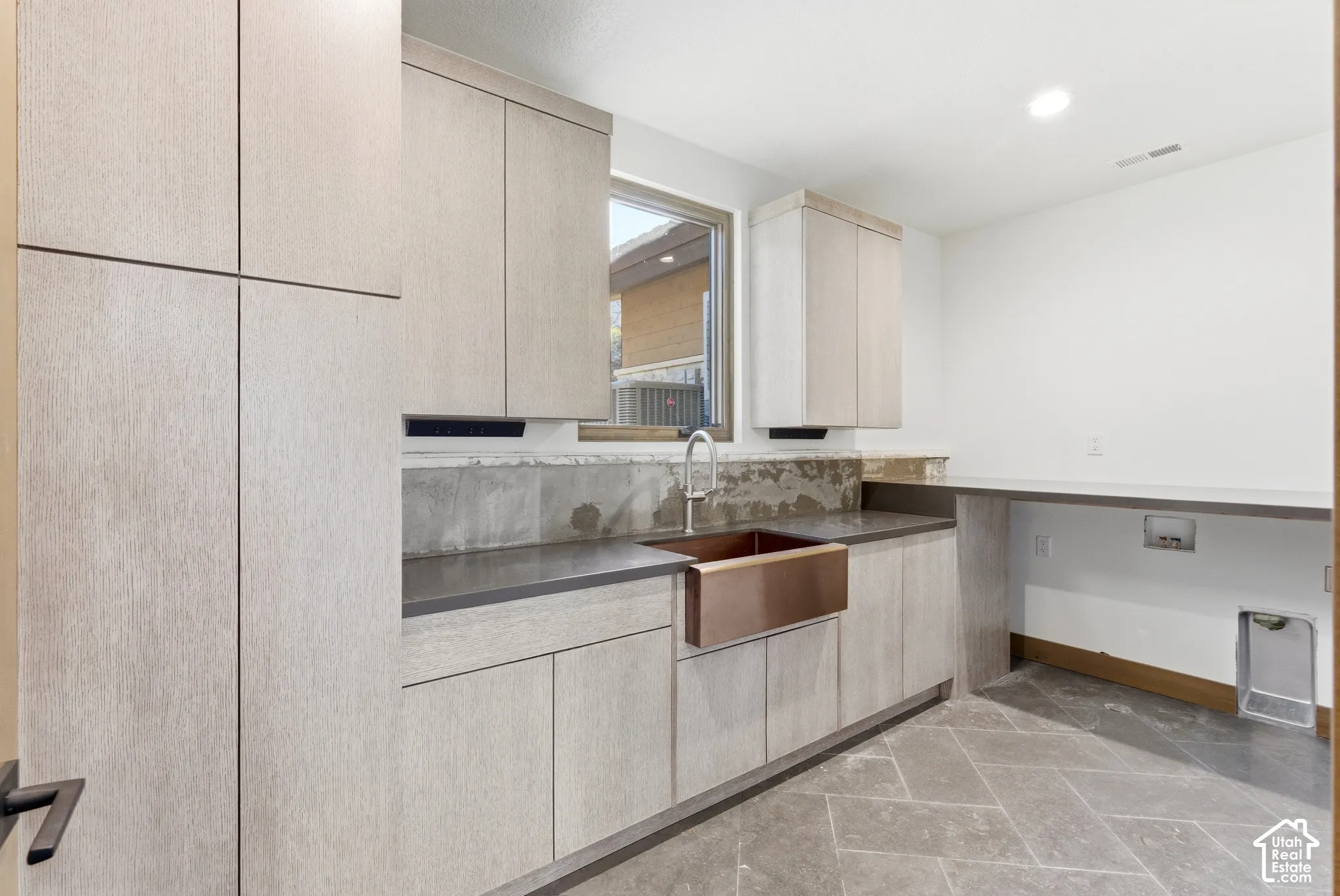 Kitchen featuring light wood finish cabinets, modern cabinets, recessed lighting, and dark countertops