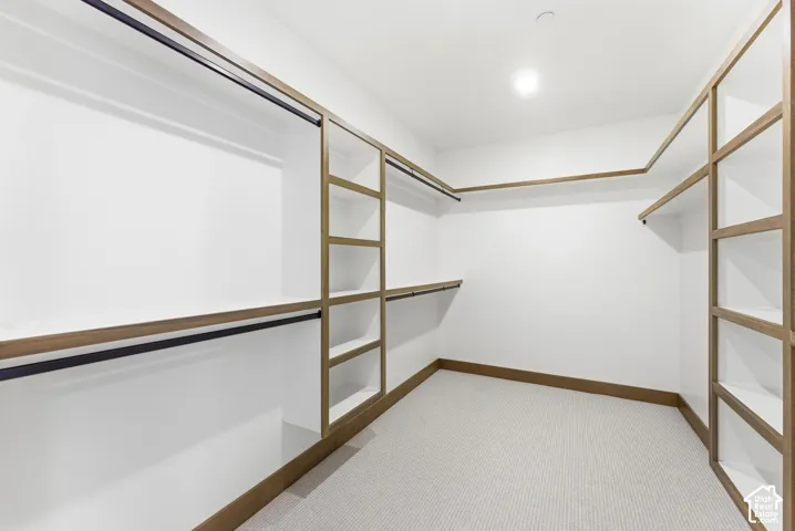 Walk in closet featuring light carpet