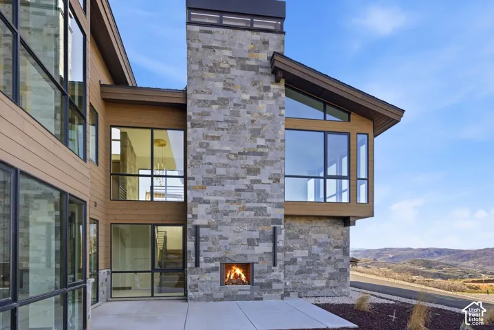 View of patio with an outdoor stone fireplace and a mountain view
