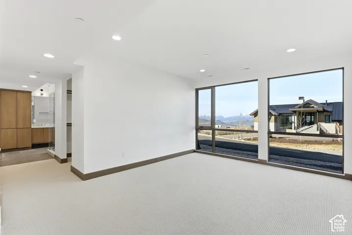 Spare room featuring light carpet, a mountain view, and recessed lighting
