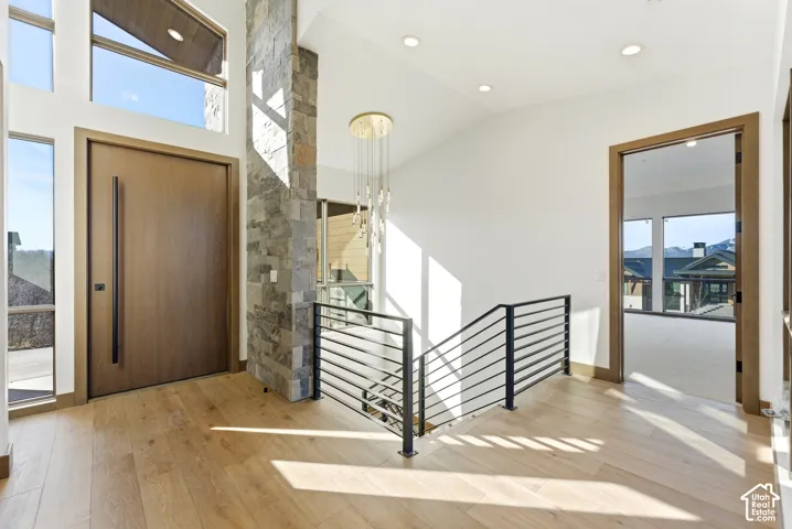 Entryway with light wood-style floors, vaulted ceiling, and recessed lighting