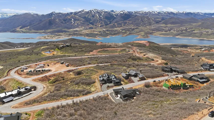 Aerial view of property and surrounding area featuring a water and mountain view and nearby suburban area
