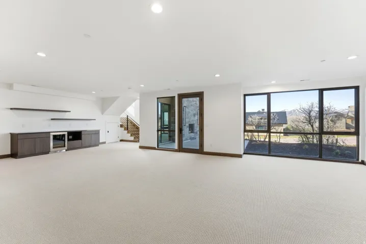 Unfurnished living room with light carpet and recessed lighting