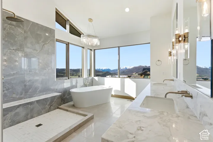 Full bath featuring a mountain view, double vanity, a freestanding tub, a marble finish shower, and recessed lighting