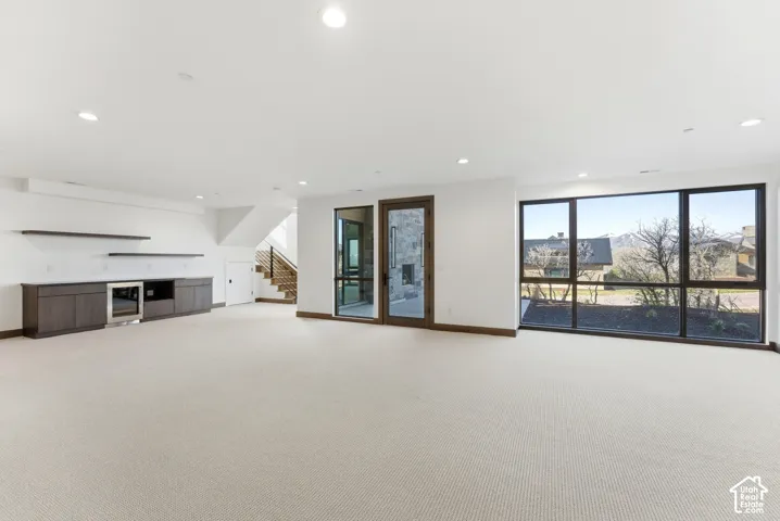 Unfurnished living room with light carpet and recessed lighting
