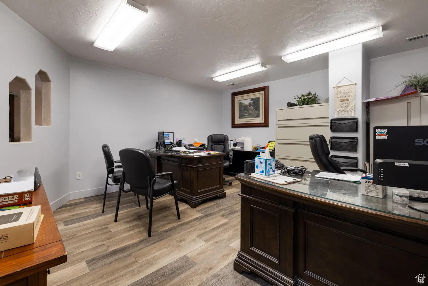 Office space with light wood-style floors and baseboards