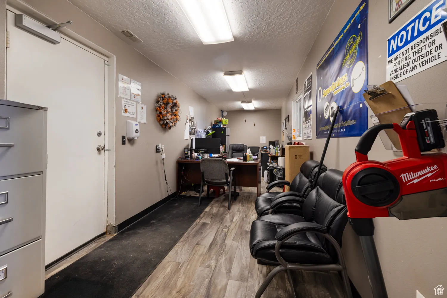 Office with a textured ceiling and wood finished floors