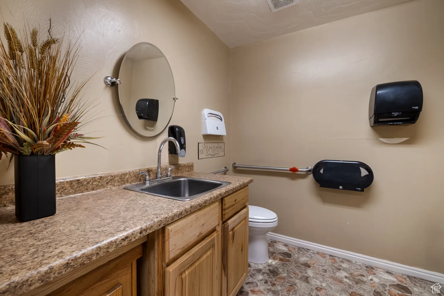 Bathroom featuring vanity, stone finish floors, and lofted ceiling
