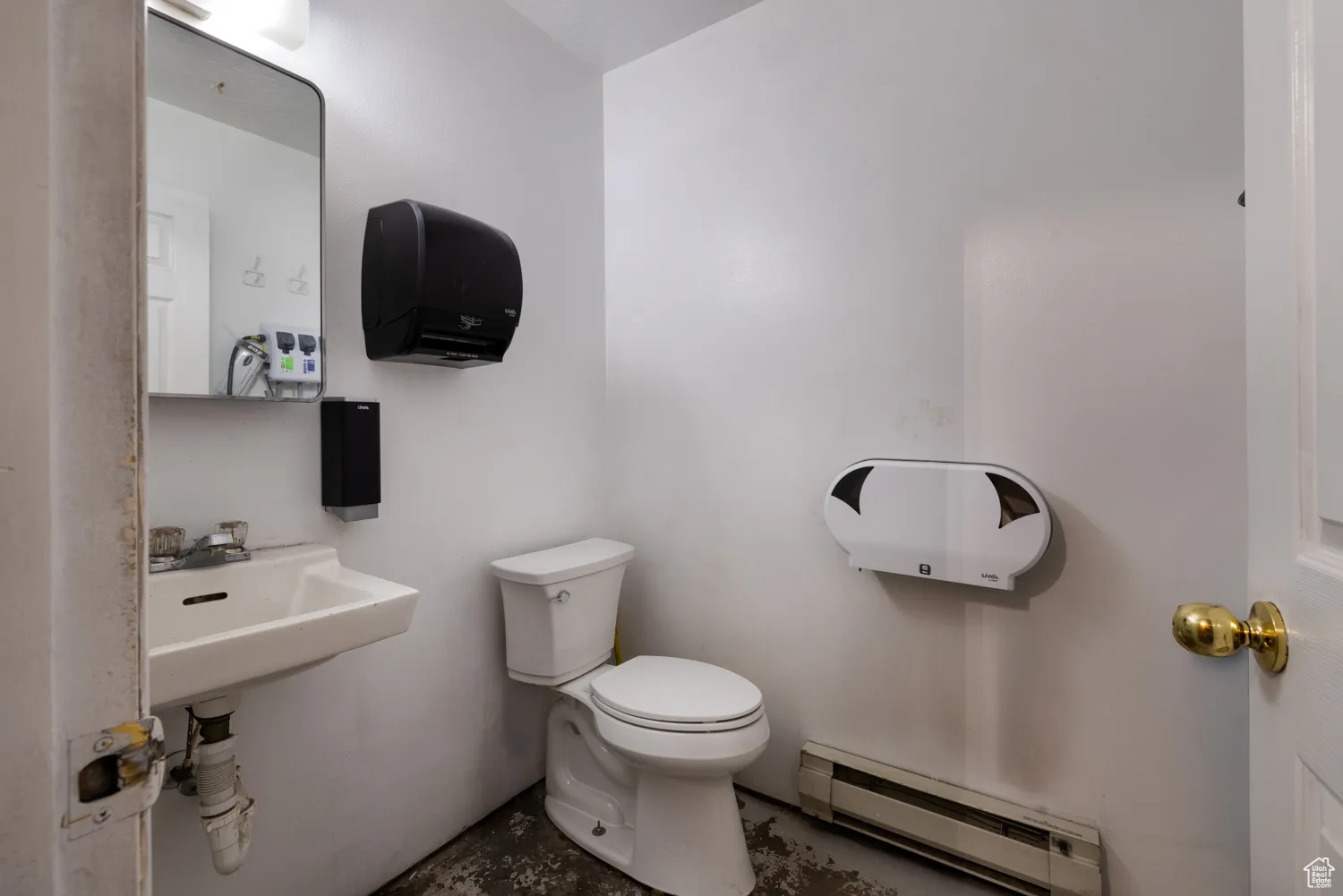Bathroom featuring a baseboard radiator and concrete floors