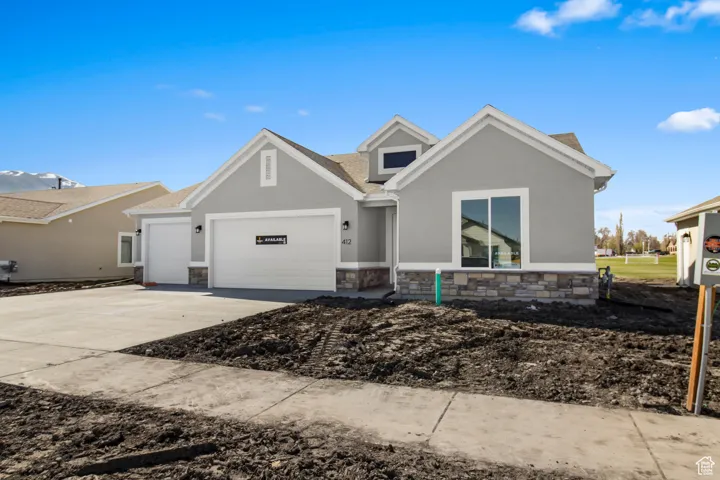 View of front of house featuring an attached garage, stone siding, concrete driveway, stucco siding, and roof with shingles