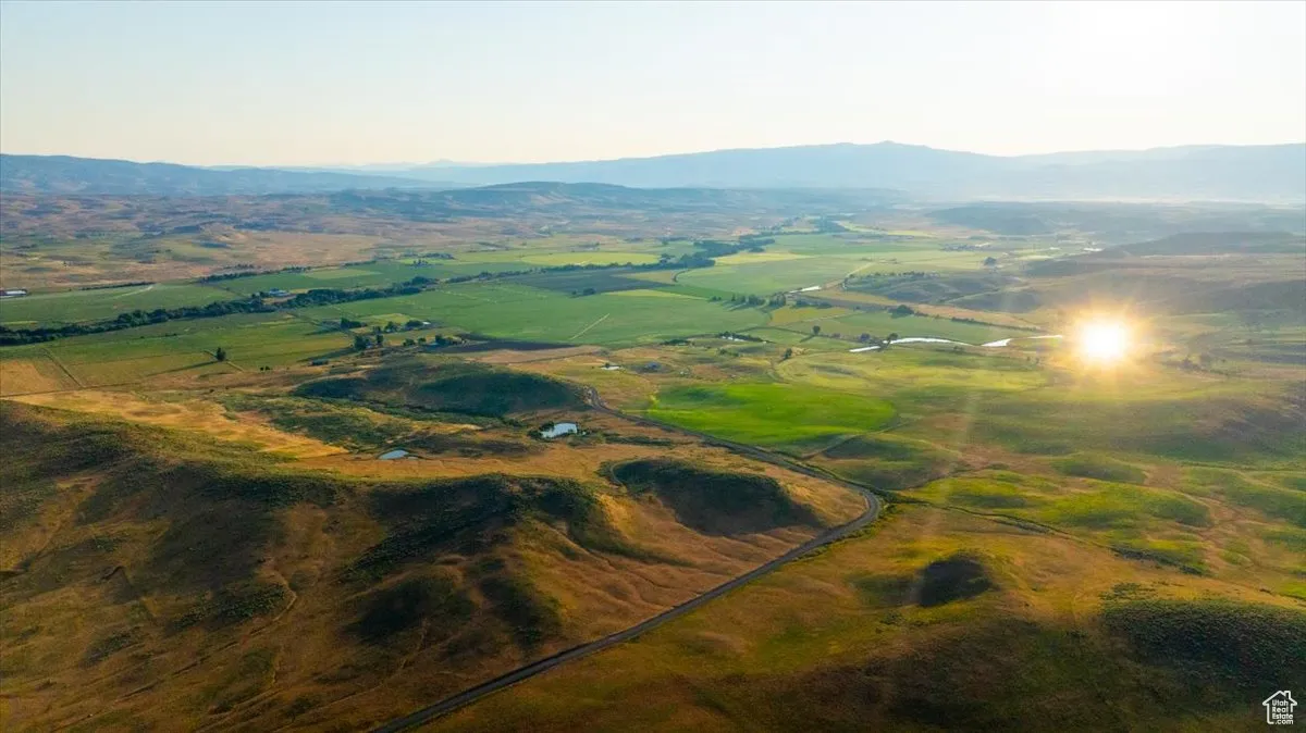 Aerial view of property's location featuring a mountainous background and rural landscape