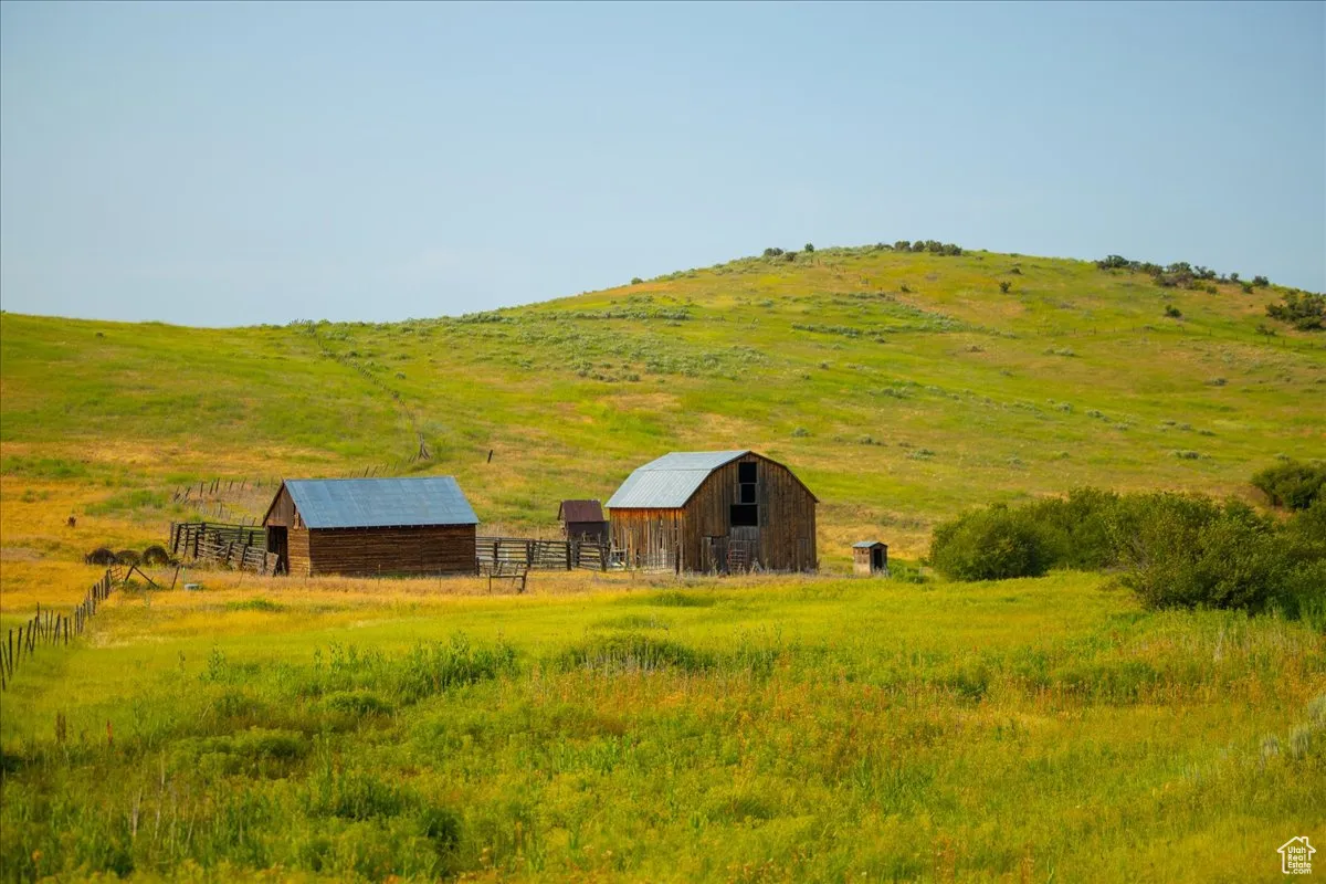 View of yard featuring a barn, a view of rural / pastoral area, an outdoor structure, and a mountain view
