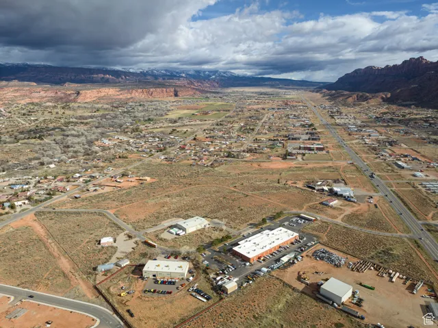 Aerial view of property and surrounding area featuring a mountain backdrop